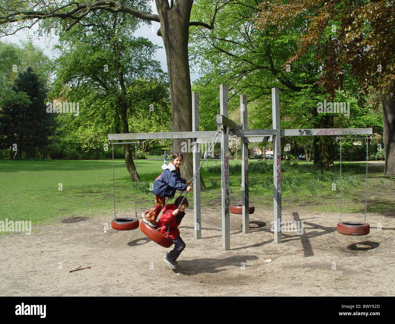 Parc Pneus Pneu swing swinging rocking fun joke joue à des jeux jeux pour enfants deux enfants Banque D'Images