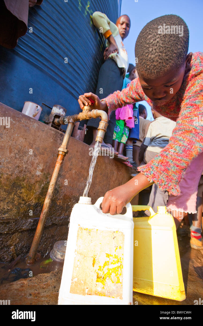 Une fille de l'eau remplissage verseuse dans Kibera, Nairobi, Kenya Banque D'Images