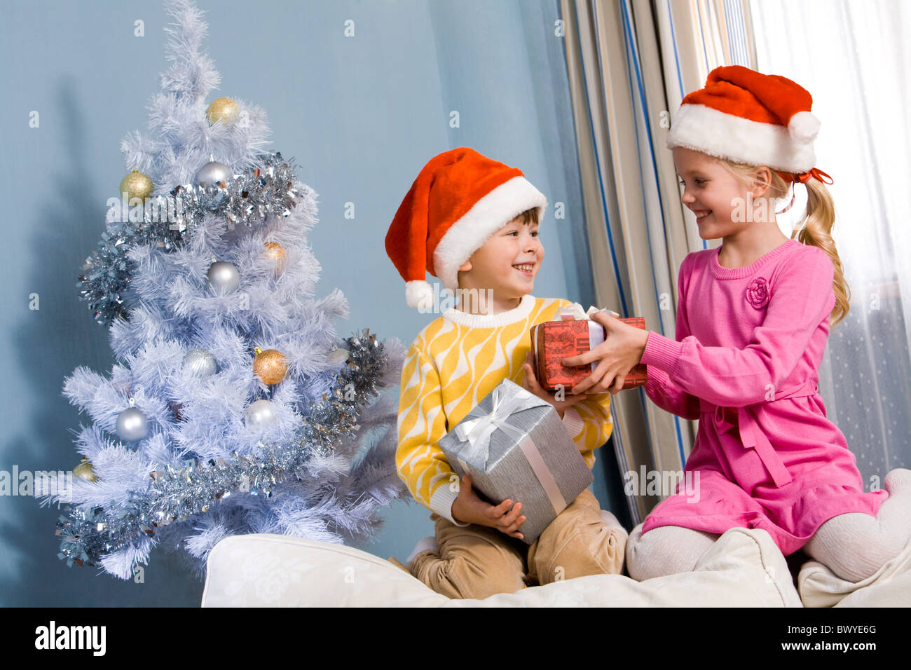 Frères et sœurs de l'échange de cadeaux de Noël à la maison Photo Stock -  Alamy