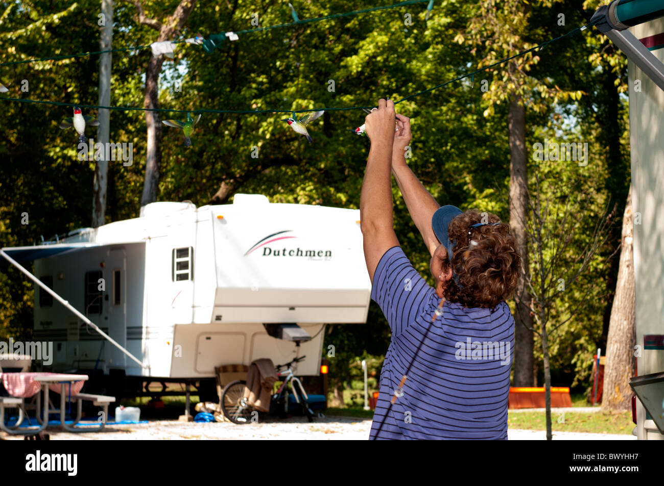Une femme dans la cinquantaine se bloque les feux de camp des colibris à partir d'un véhicule de plaisance. USA. Banque D'Images