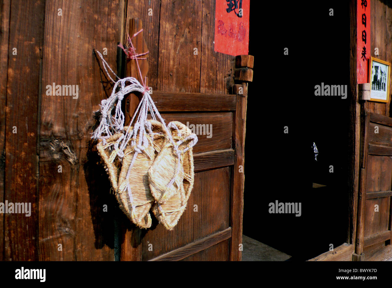 Sandales de paille accroché sur la porte de bois d'une maison traditionnelle, ancienne ville Qingyan, Guiyang, Guizhou Province, China Banque D'Images