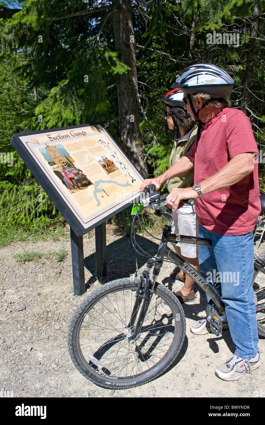 L'homme et la femme les cyclistes lire l'un des plaques historiques sur le sentier d'Hiawatha, New York, USA. Banque D'Images
