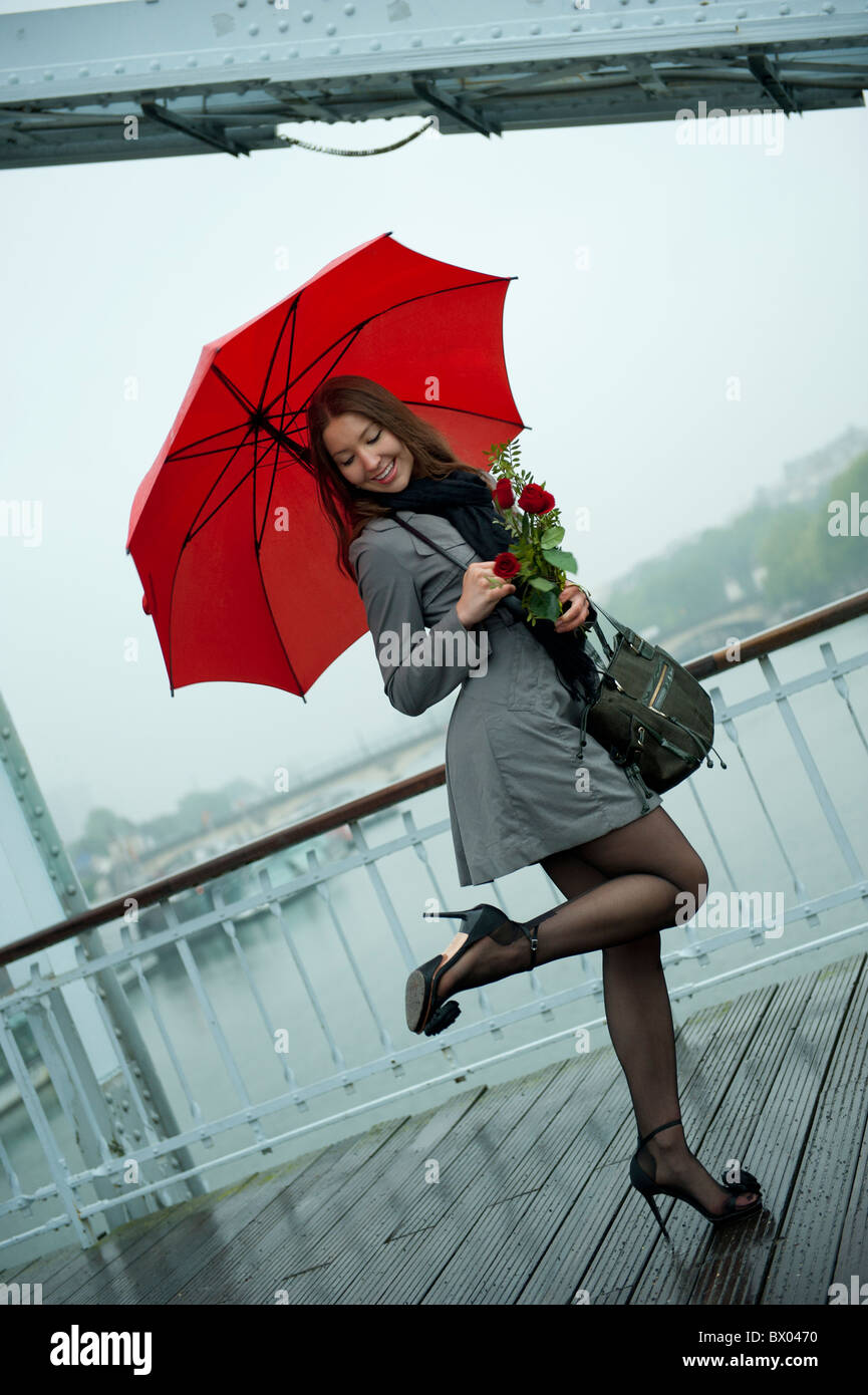 Caucasian woman en hautes chaussures de talon avec parapluie rouge Photo  Stock - Alamy
