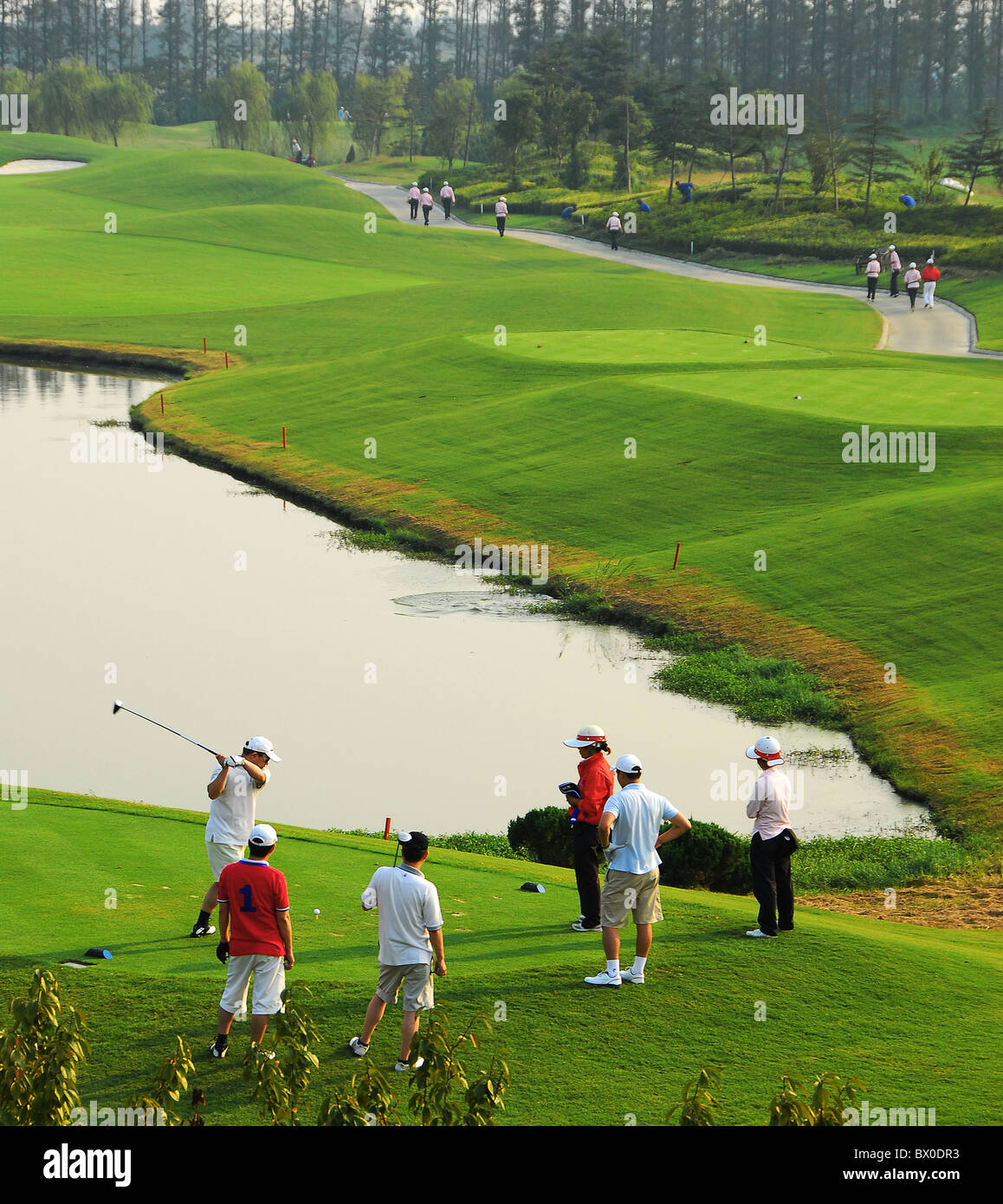 Les golfeurs jouant dans un luxuriant parcours de golf, Taicang, Province de Jiangsu, Chine Banque D'Images