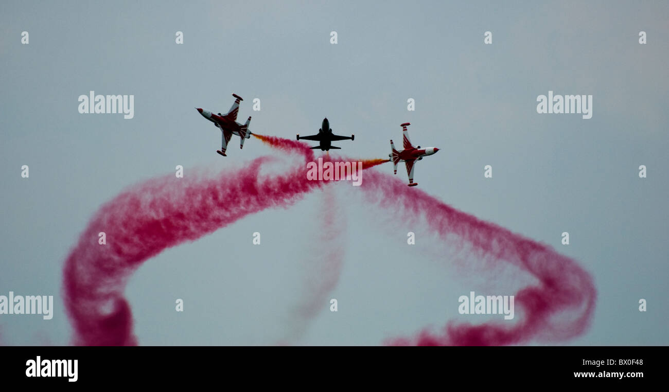 Trois étoiles turc Northrop NF-5 en formation - ayant récemment terminé un cross-over avec arrière fumée rouge vif Banque D'Images