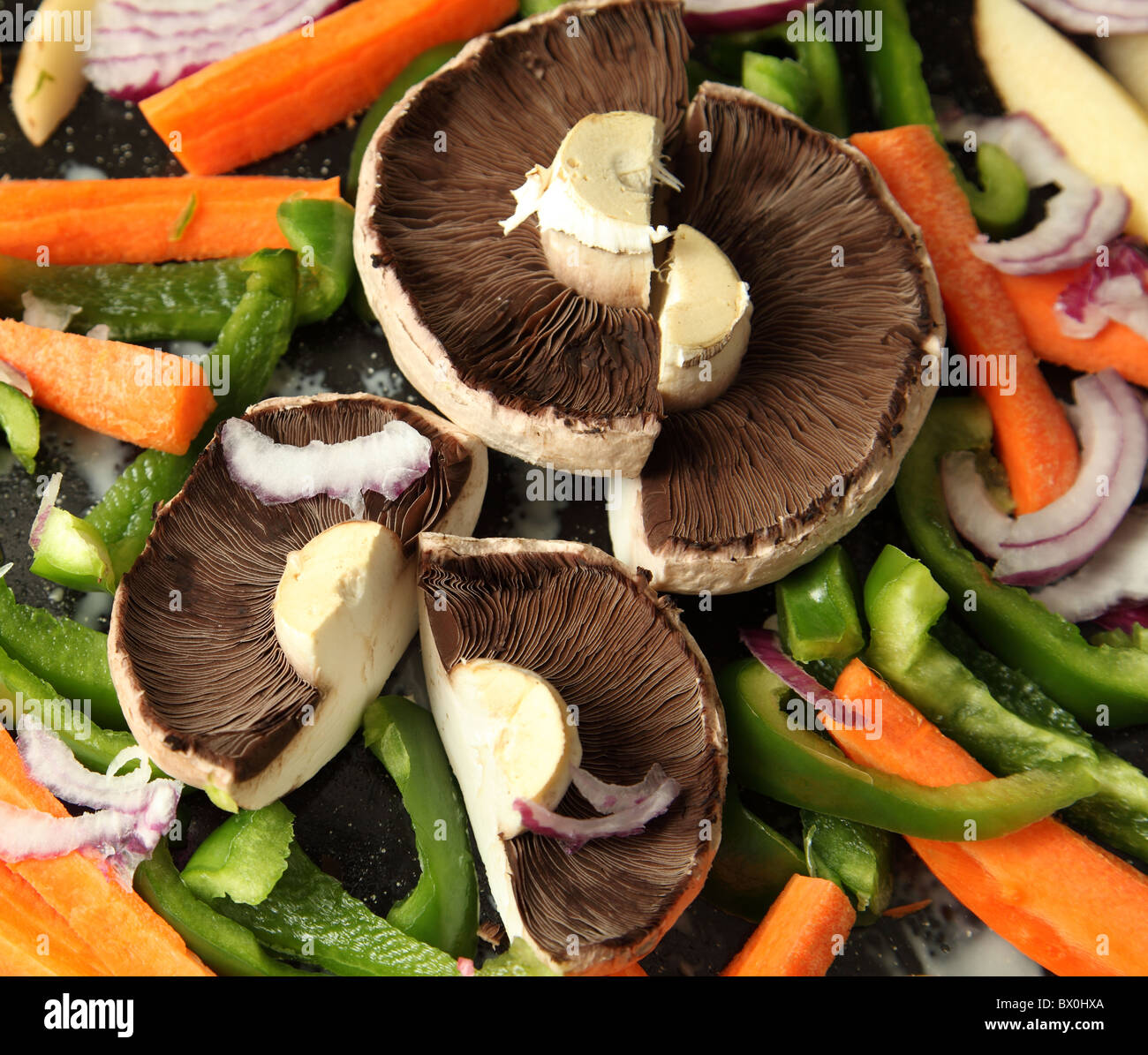 Les champignons et poivrons préparés pour la torréfaction. Banque D'Images
