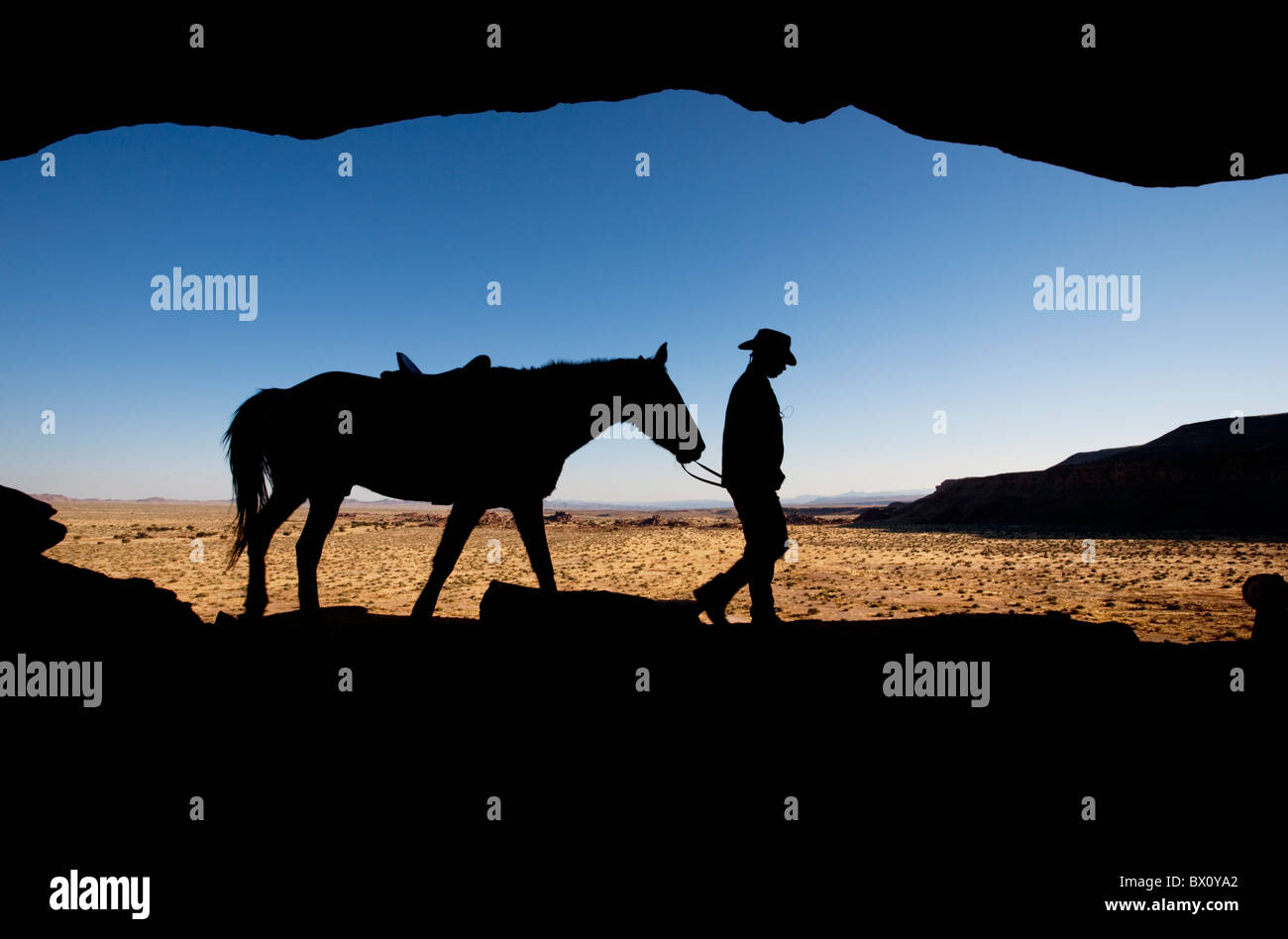 Silhouette d'un homme conduisant son cheval le long d'une crête, Fish River Canyon, la Namibie, l'Afrique. Banque D'Images