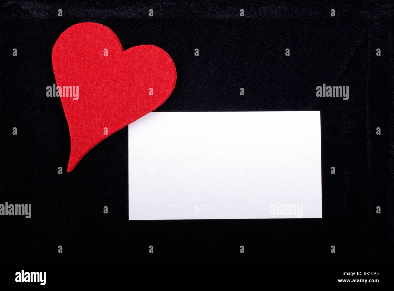 Coeur rouge carte vide et isolé sur fond de velours noir. L'espace vide pour votre texte ou dessin. Banque D'Images
