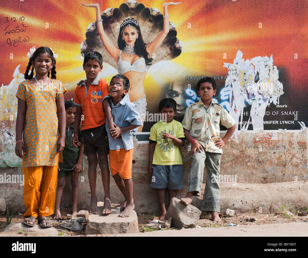 Les enfants indiens debout devant une affiche de film Telugu dans un indien dans la rue Kothacheruvu, Andhra Pradesh, Inde Banque D'Images