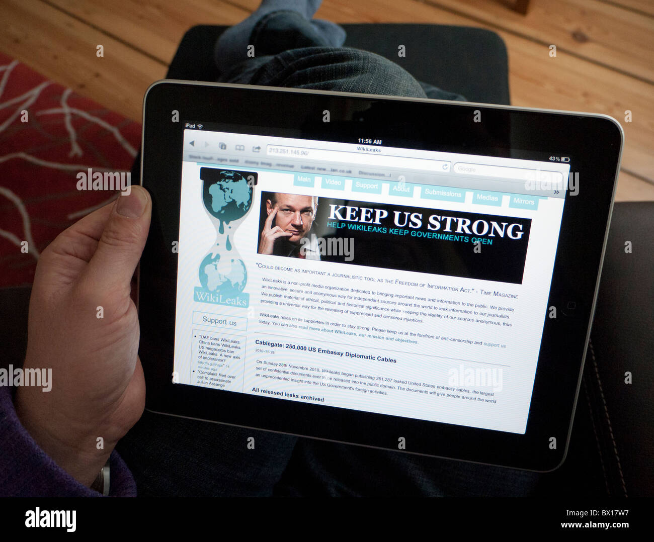 La lecture de l'homme site web de Wikileaks sur un iPad tablet computer Banque D'Images