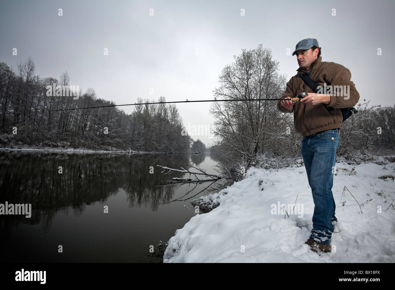 En hiver, un pêcheur sur la rive de la rivière Allier (France). Pêcheur à la ligne sur une des berges de l' Allier, en hiver. Banque D'Images