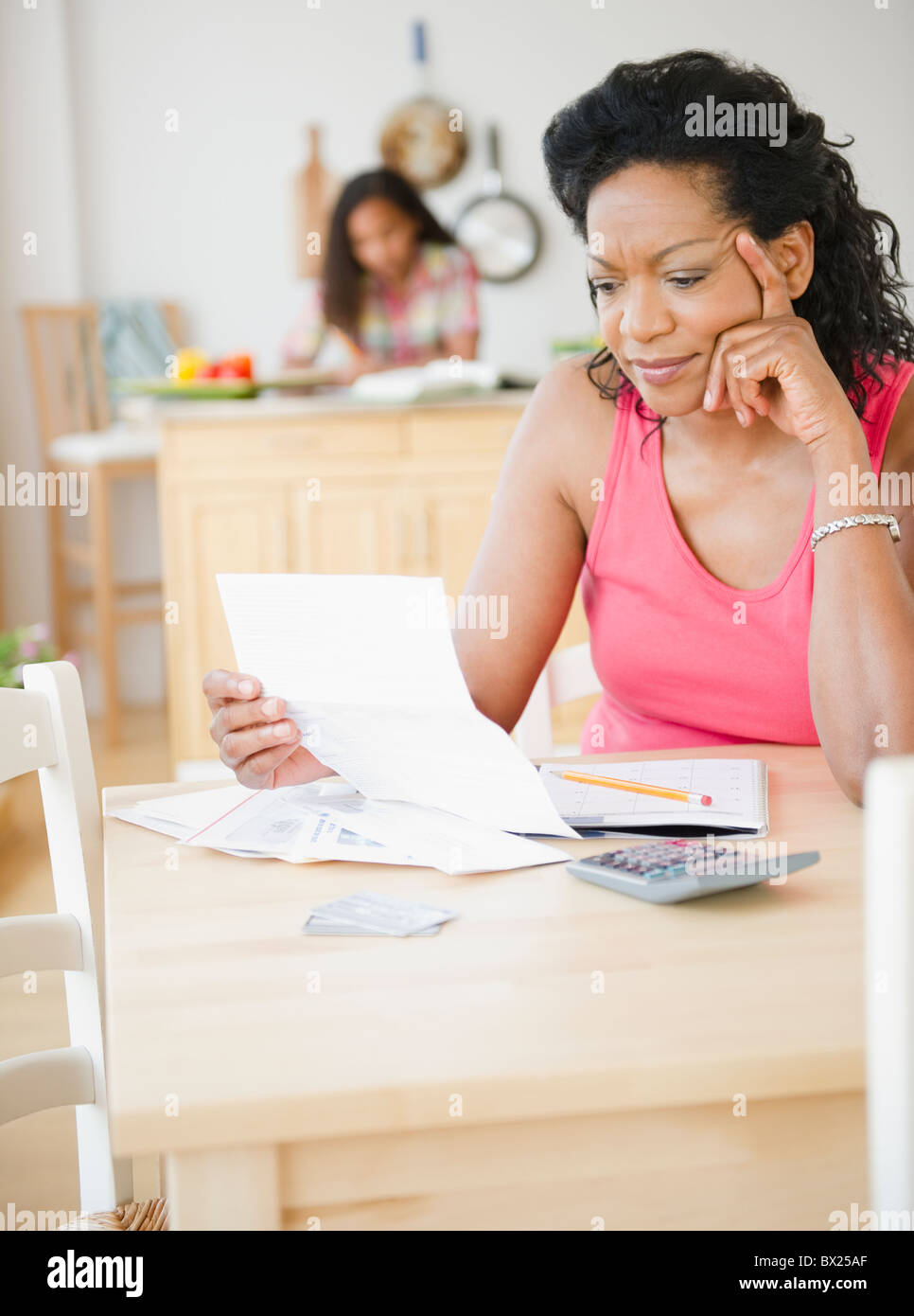 Black mère regardant factures mensuelles Banque D'Images