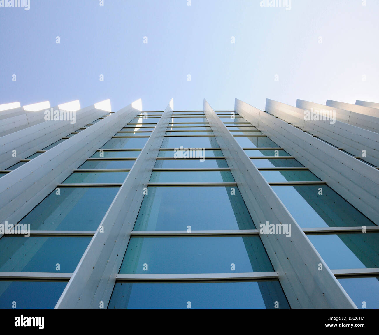 Les fenêtres extérieures d'un immeuble de bureaux commerciaux à up depuis le sol avec ciel bleu reflété dans windows Banque D'Images