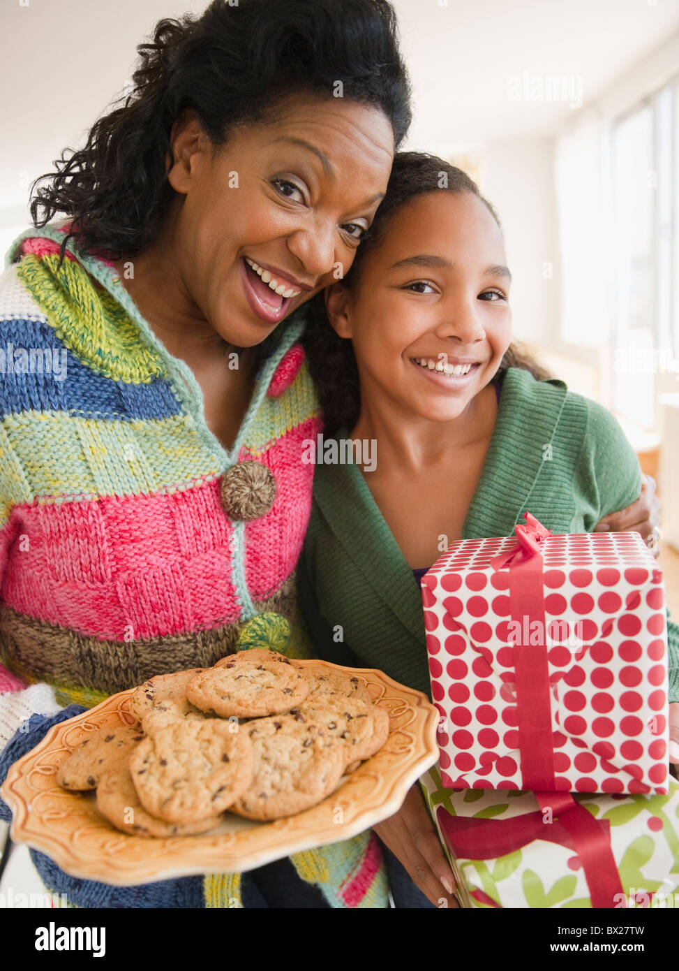 Mère et fille exerçant son cadeau d'anniversaire et les cookies Banque D'Images