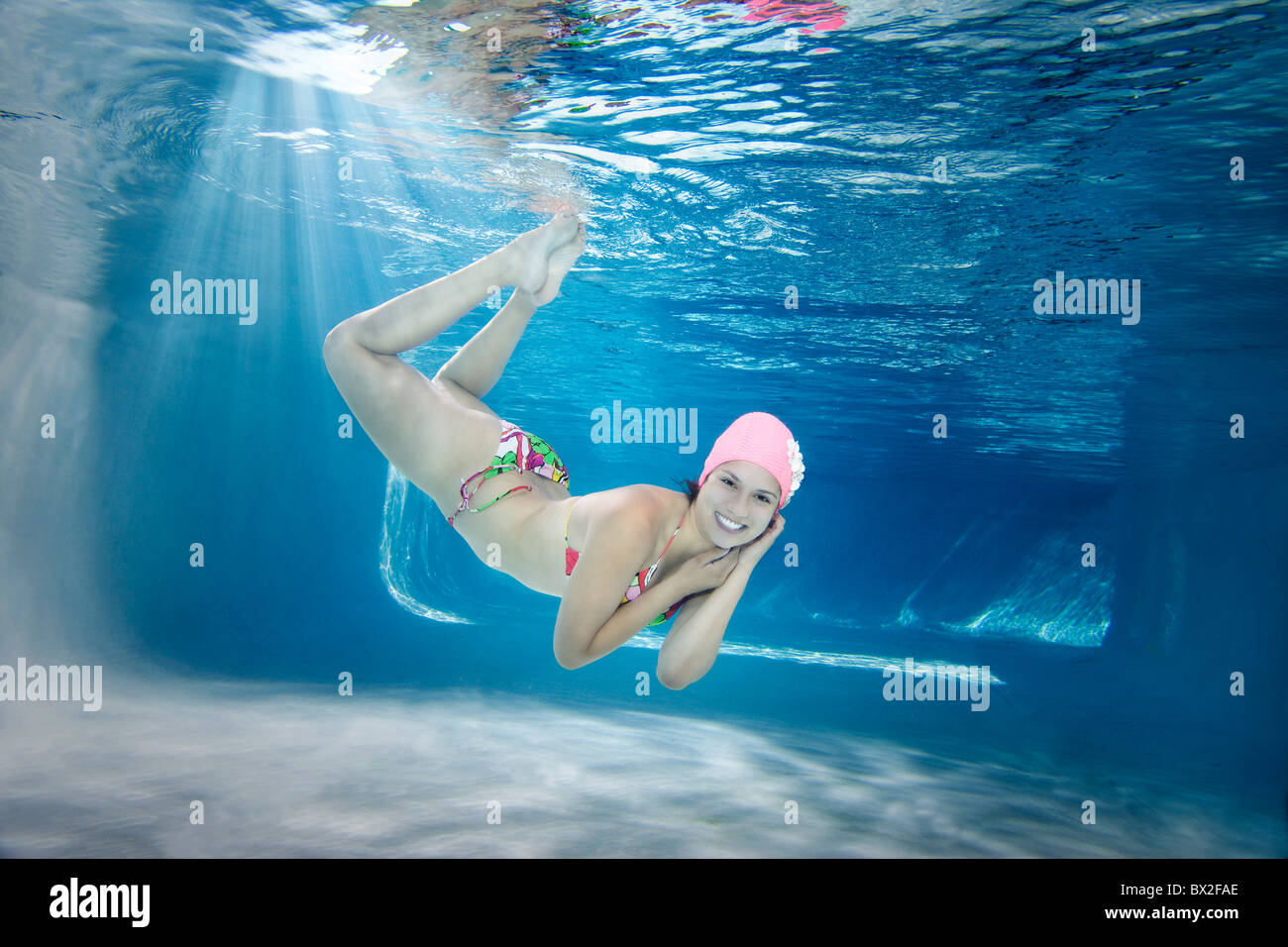 Hispanic woman in bikini swimming underwater Banque D'Images