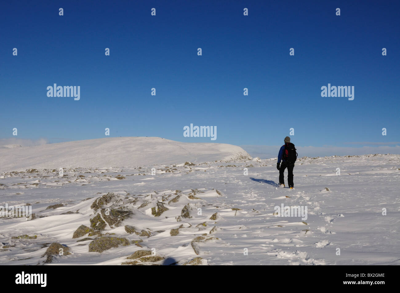 Hiver Randonnées en montagne dans le Lake District. Walker sur Nethermost pike position pour Helvellyn Banque D'Images