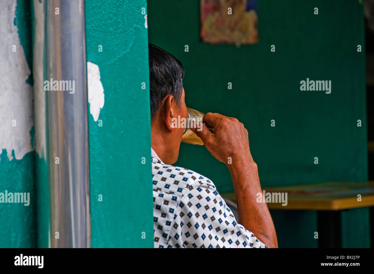 Mâle ethniques assis à table dans le restaurant en plein air dans la région de Little India à Singapour Banque D'Images