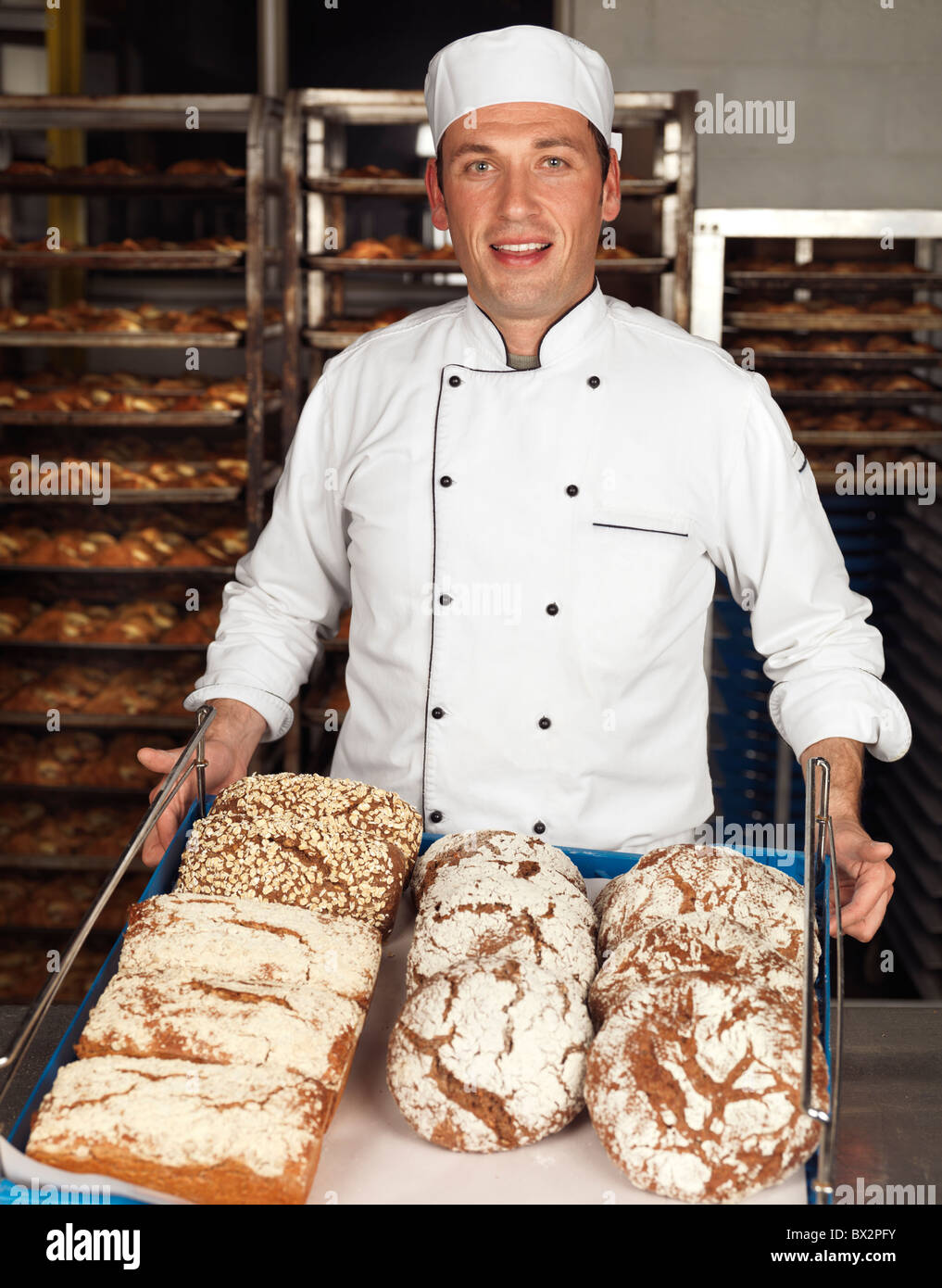 Portrait of a baker tenant un plateau avec des petits pains dans une boulangerie Banque D'Images