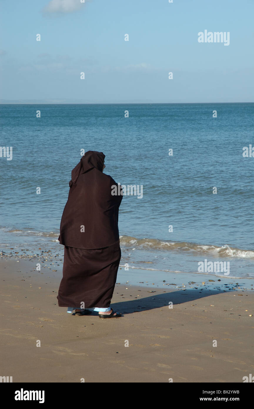 Femme musulmane face à la mer, Tenby, Pays de Galles, Royaume-Uni Banque D'Images