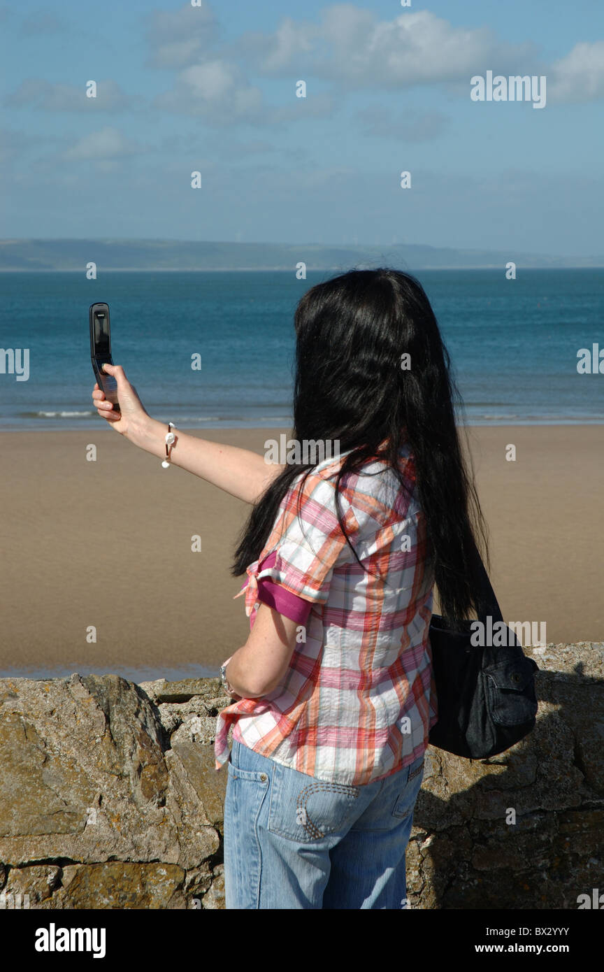 Woman taking photo avec téléphone mobile, Tenby, Pays de Galles, Royaume-Uni Banque D'Images