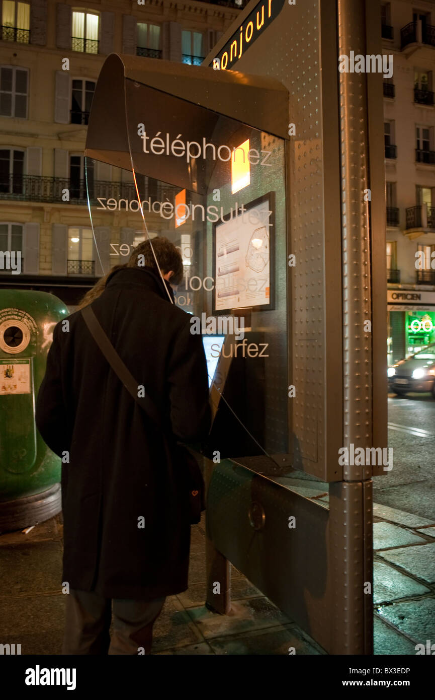 Paris, France, jeune couple à l'aide de Téléphone Internet sur rue dans le quartier du Marais la nuit Banque D'Images