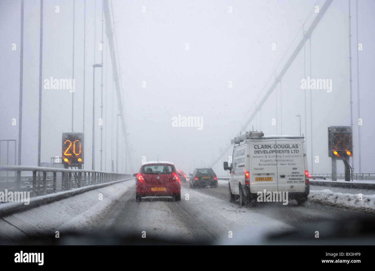 Voitures traversant le pont de Forth Road de mauvaise conditions hivernales. Banque D'Images
