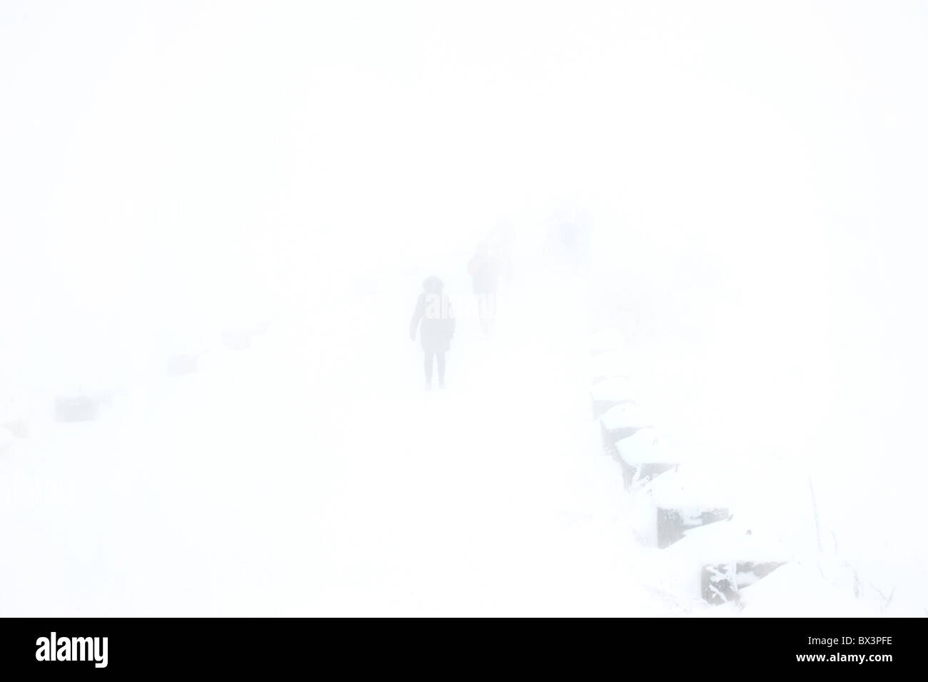 Les gens à pied par la route de fortes chutes de neige Banque D'Images