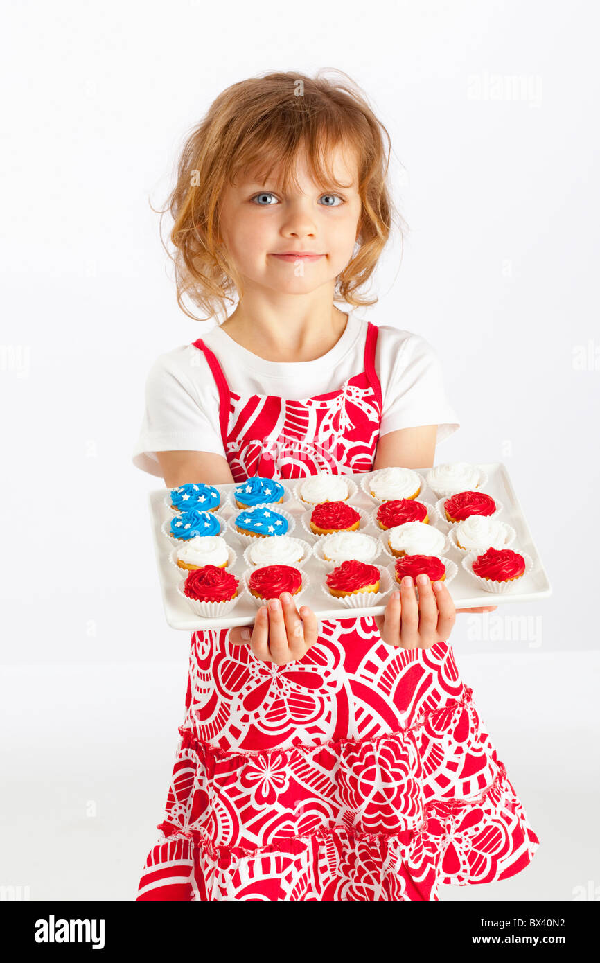 Une jeune fille tenant une assiette de Cupcakes Banque D'Images