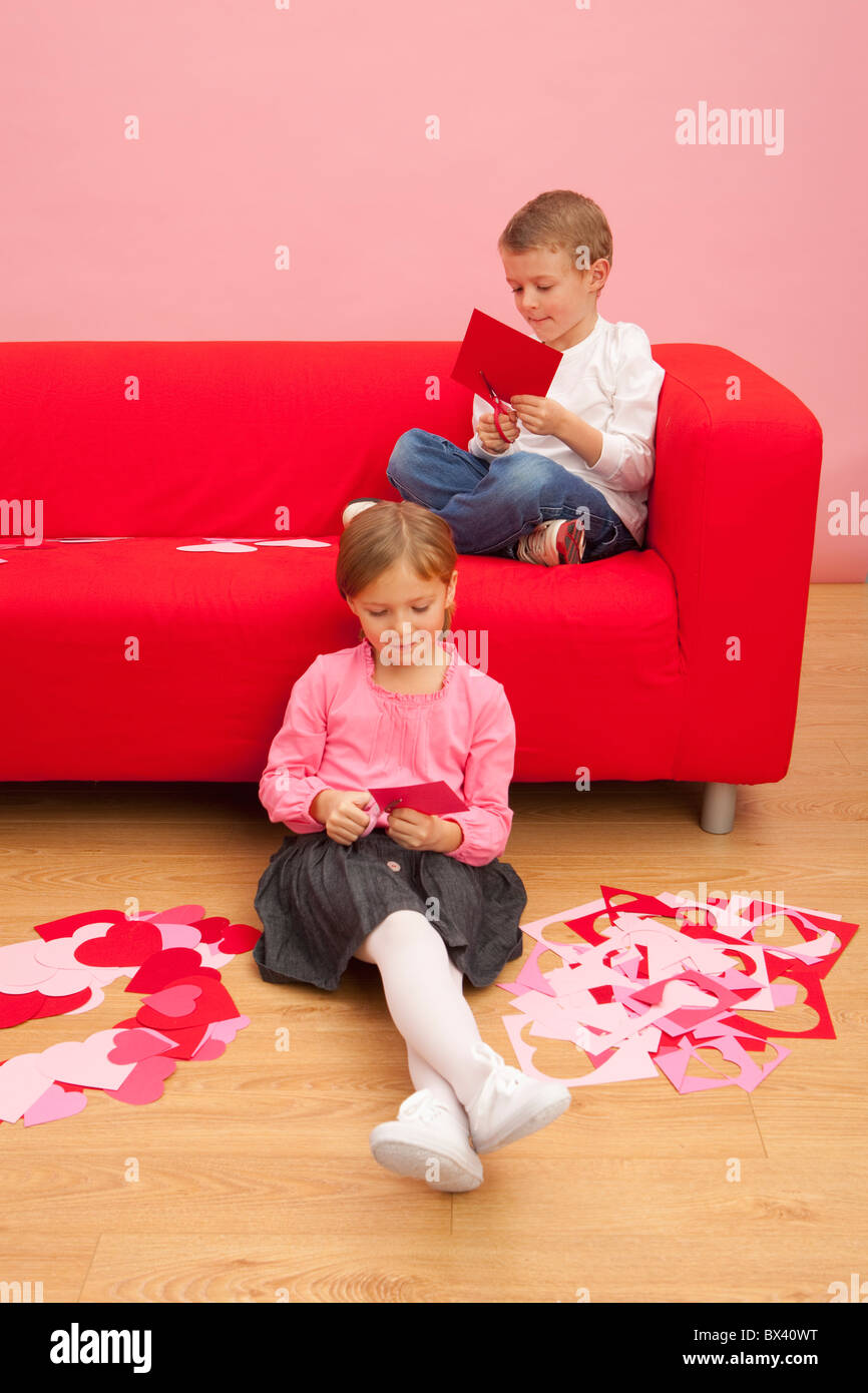 Un garçon et une fille se coupe divers coeurs colorés Banque D'Images