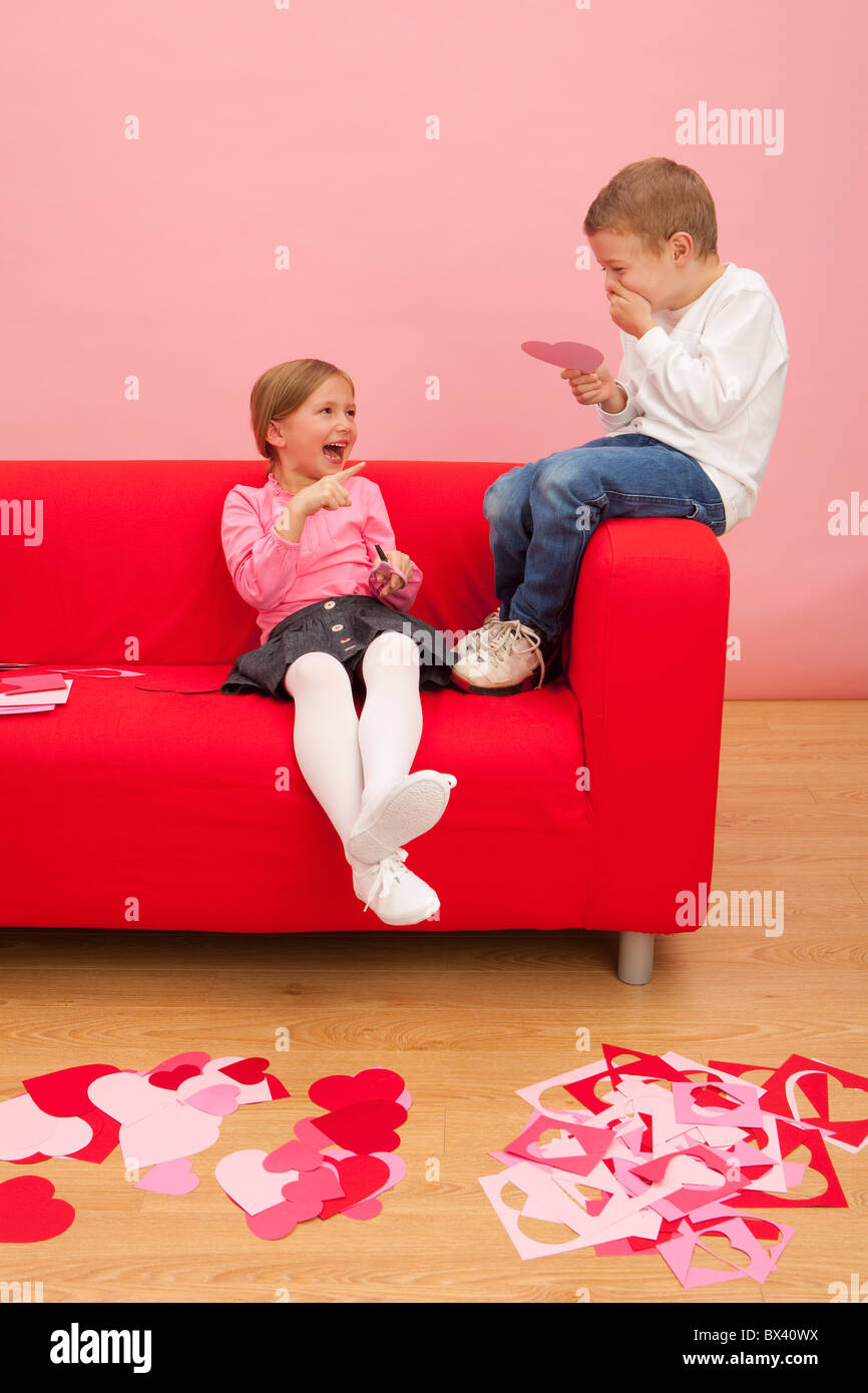 Un garçon et une fille se coupe divers coeurs colorés et d'être bête ensemble Banque D'Images