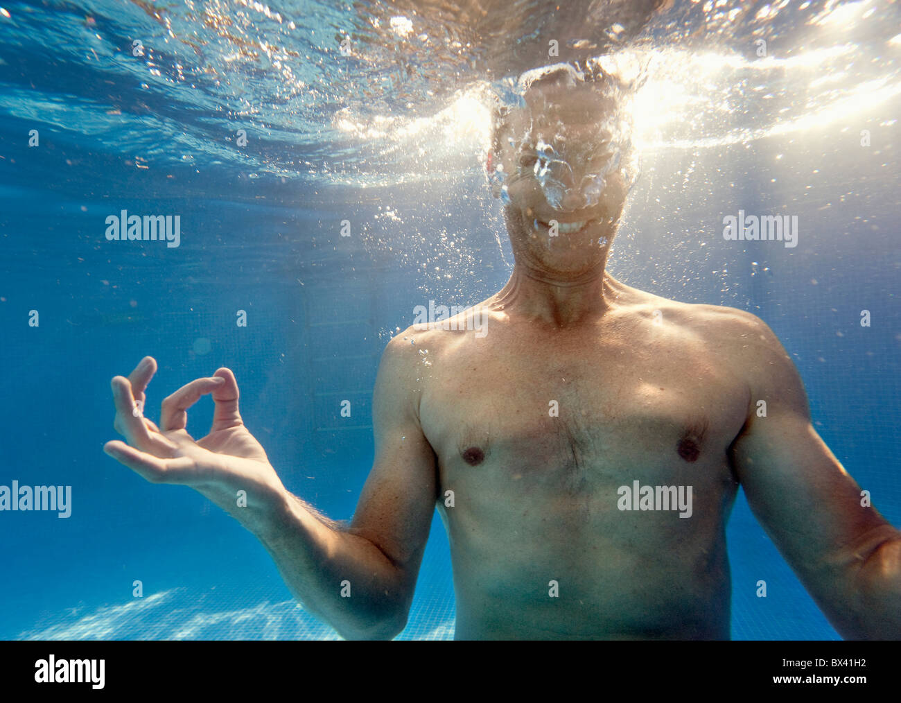 Un homme faisant une médiation posent sous l'eau ; Benalmadena Costa, Malaga, Andalousie, Espagne Banque D'Images