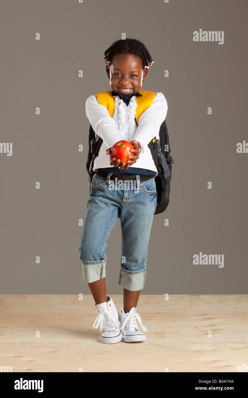 Une fille avec un sac à dos Holding An Apple Banque D'Images