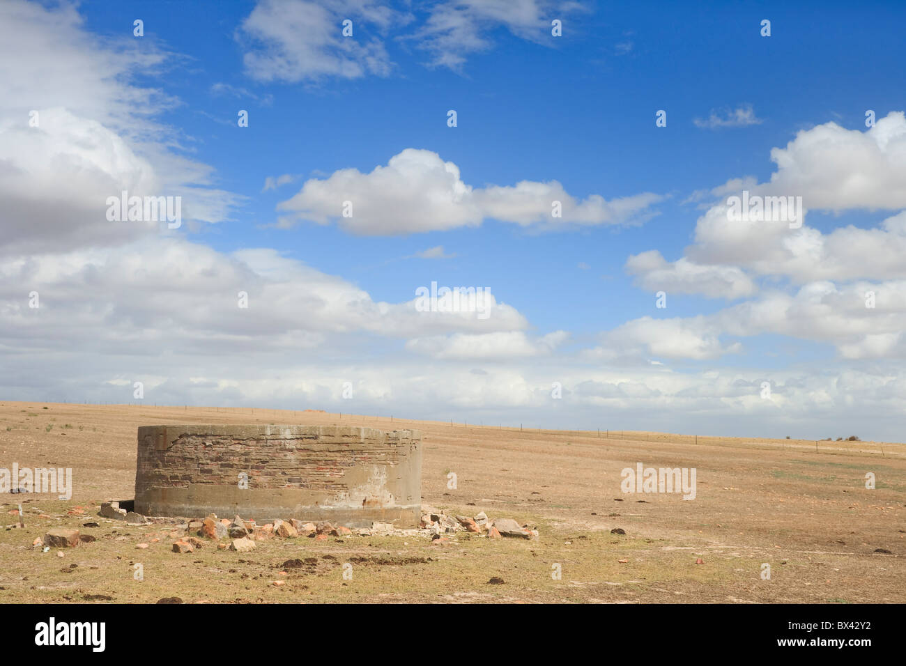 Un réservoir d'eau en train de s'effondrer sur une ferme avec des cultures non stérile, le ciel a des nuages mais pas la pluie Banque D'Images