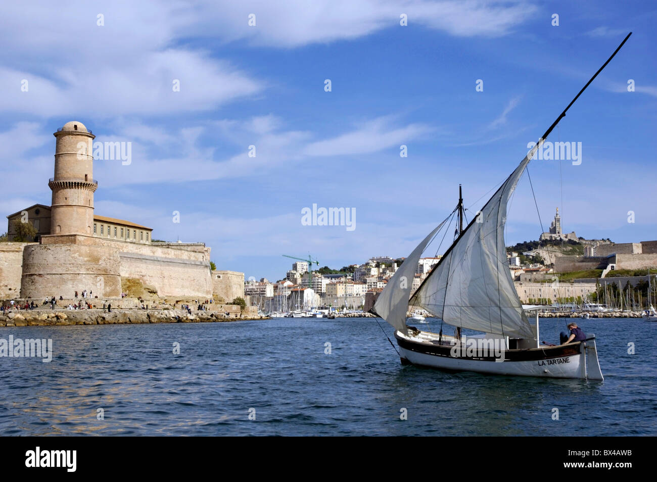 Marseille, France, homme naviguant dans un yacht avec Saint Jean Fort en arrière-plan Banque D'Images