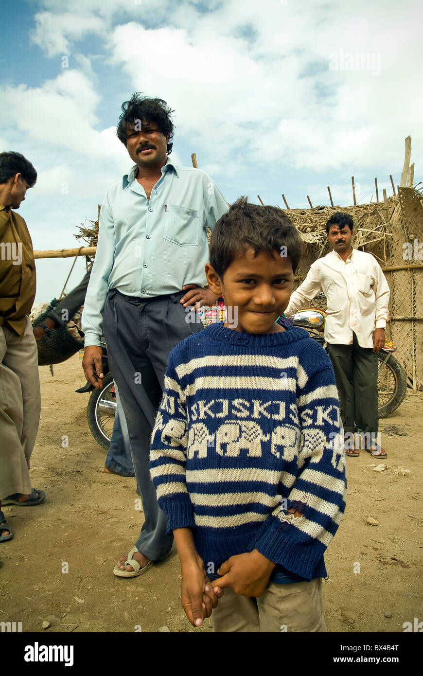 Jeune garçon et les villageois dans un petit village de pêcheurs sur l'île de Diu, Inde Banque D'Images