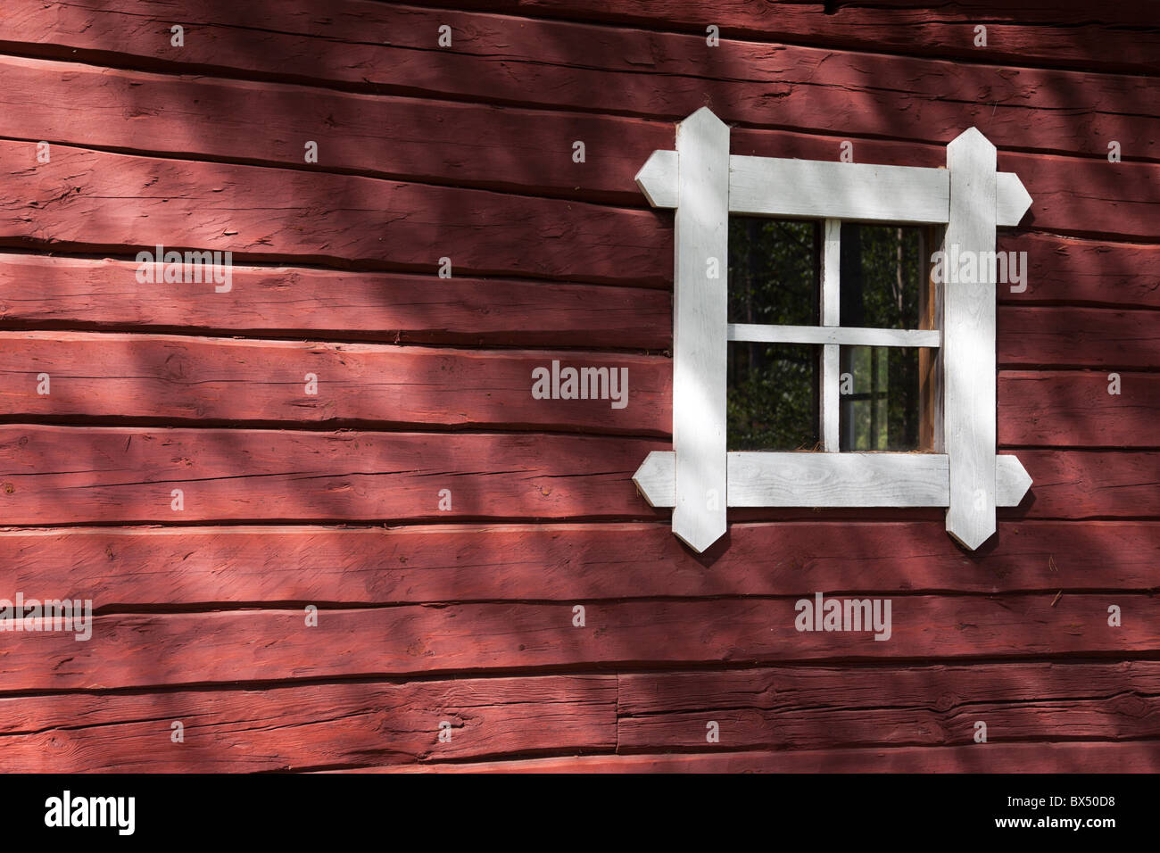 Vieux mur de la cabine en bois peint en ocre rouge et une petite fenêtre, Finlande Banque D'Images