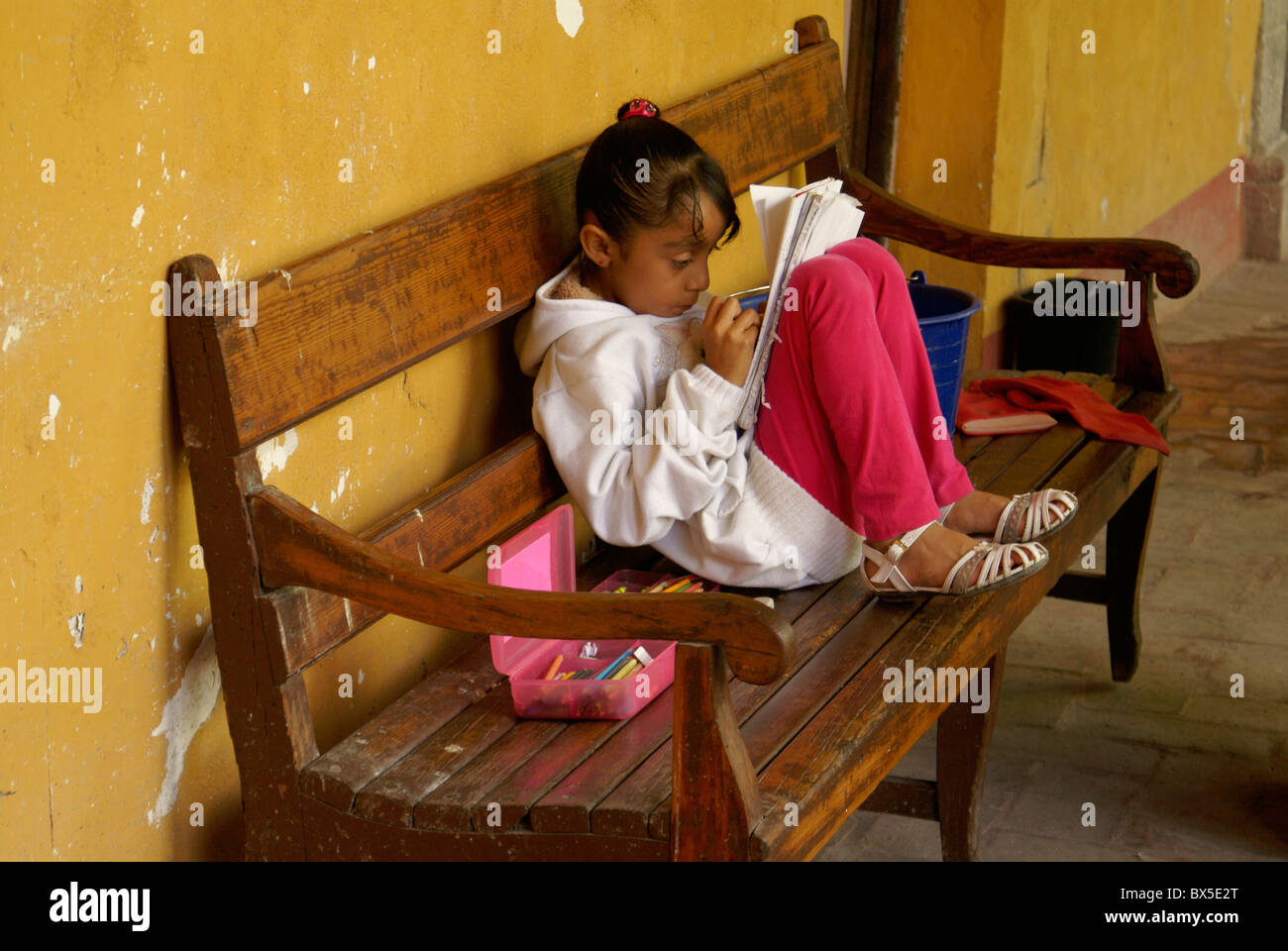 Jeune fille lisant et la coloration à San Miguel de Allende, Mexique. San Miguel de Allende est un UNESCO World Heritage Site. Banque D'Images