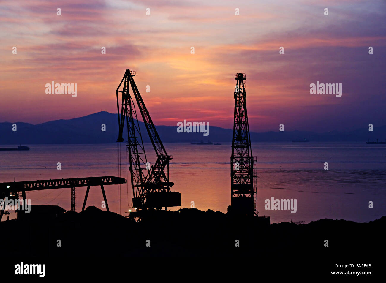 Grues portuaires contre un déclin rouge Banque D'Images