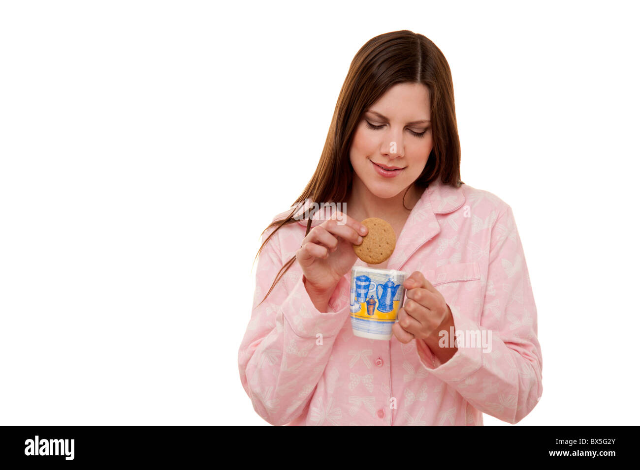 Tremper un biscuit dans femme une tasse de thé Banque D'Images
