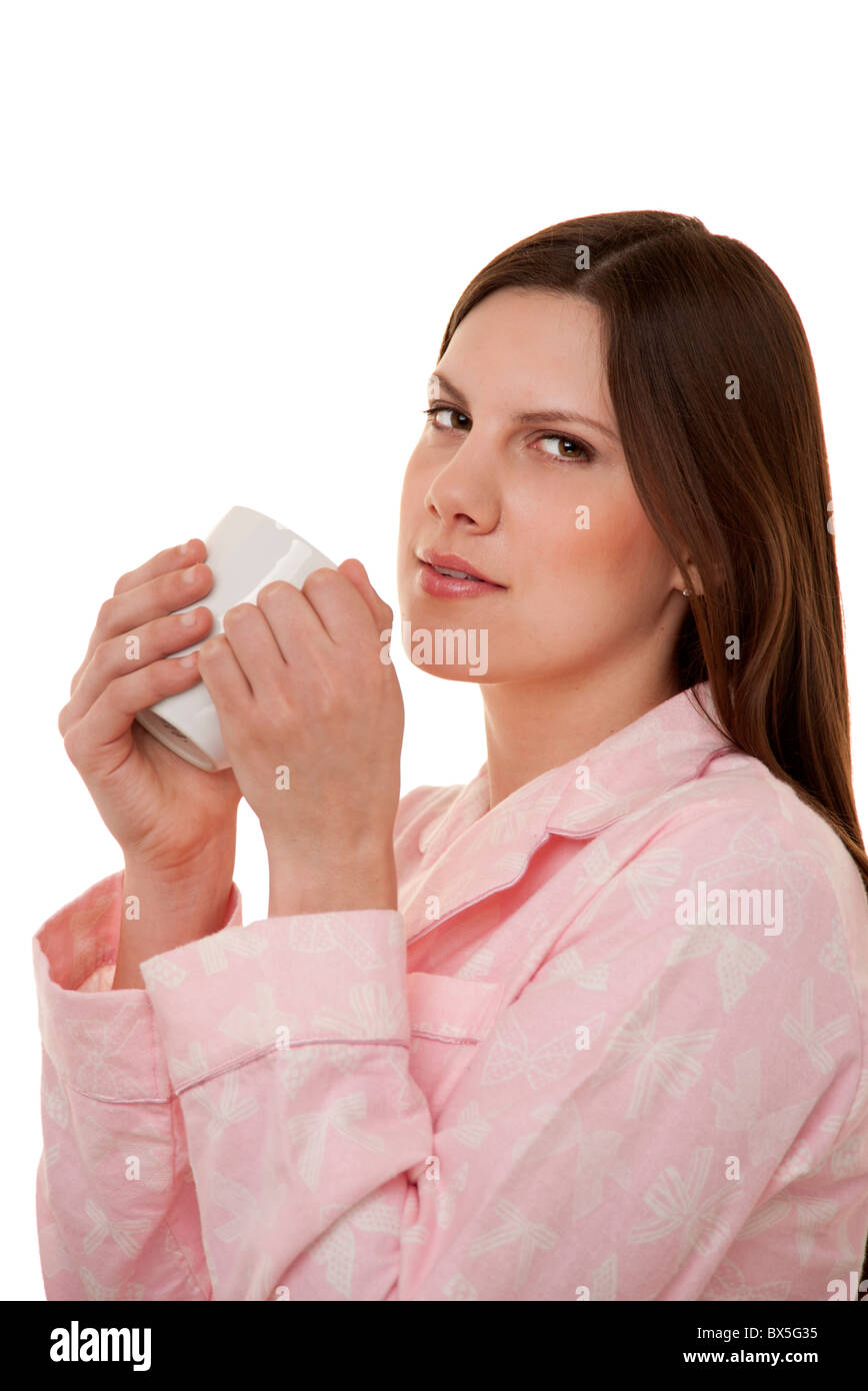 Femme buvant une tasse de thé dans son pyjama Banque D'Images