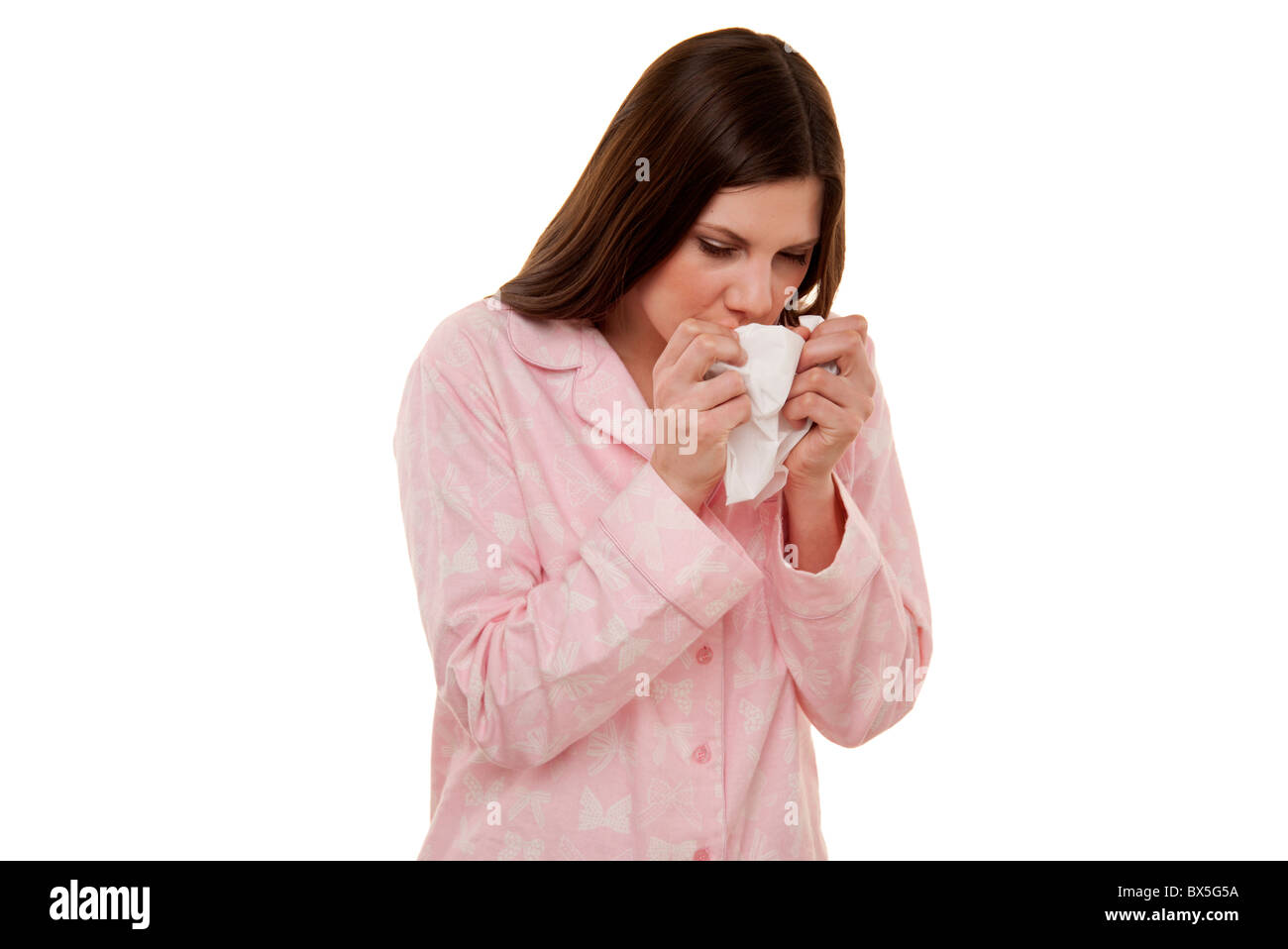 Femme éternuements , un rhume wearing pajamas. Banque D'Images