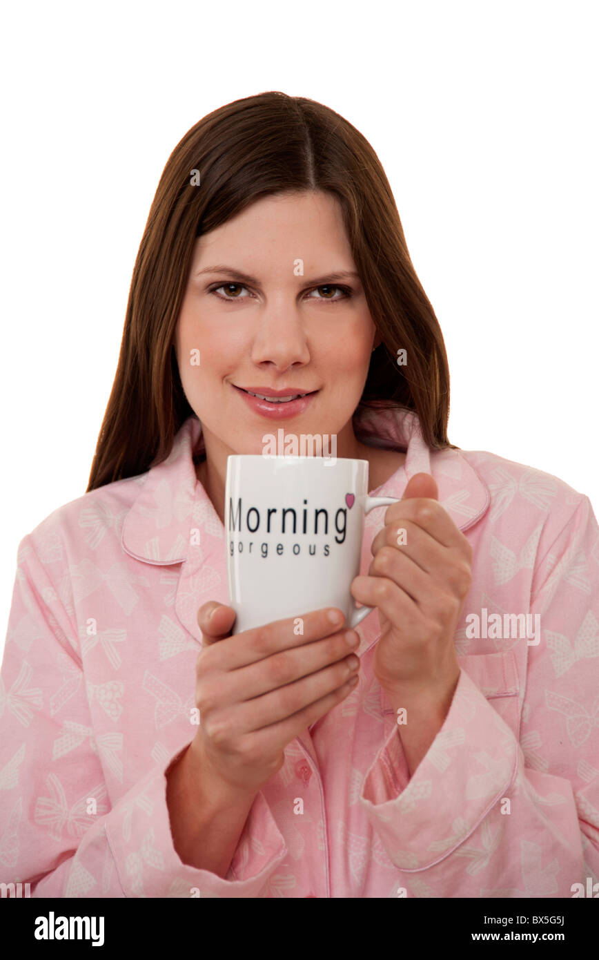 Brunette woman holding mug de thé dans son pyjama Banque D'Images