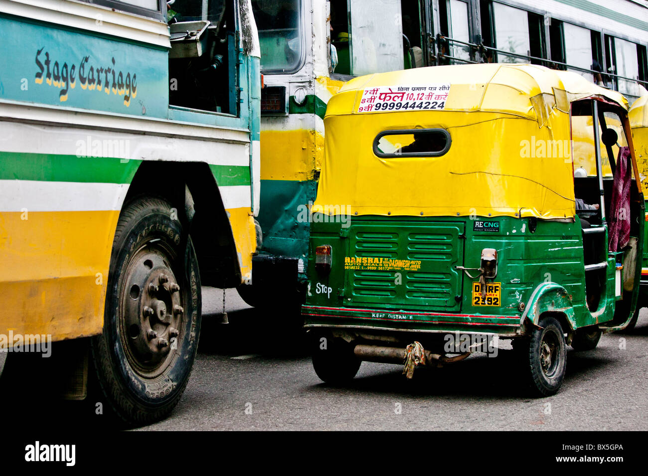 Trafic typique à New Delhi - jaune et vert de tuk-tuk taxis se bousculent pour la position. Banque D'Images