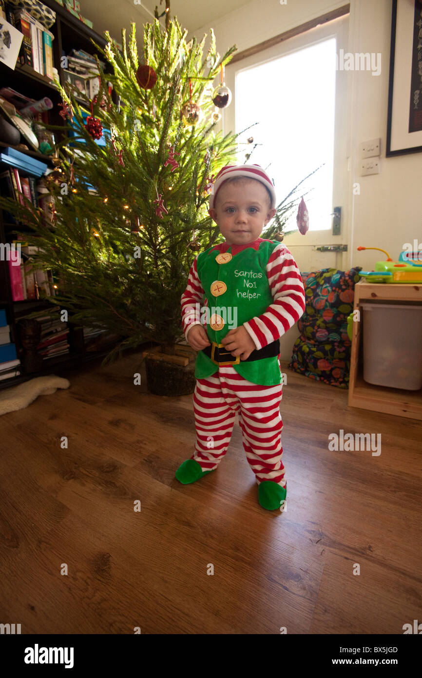 Un petit garçon habillé en lutin de Noël, Santa's Little Helper. Hampshire, Angleterre, Royaume-Uni. Banque D'Images