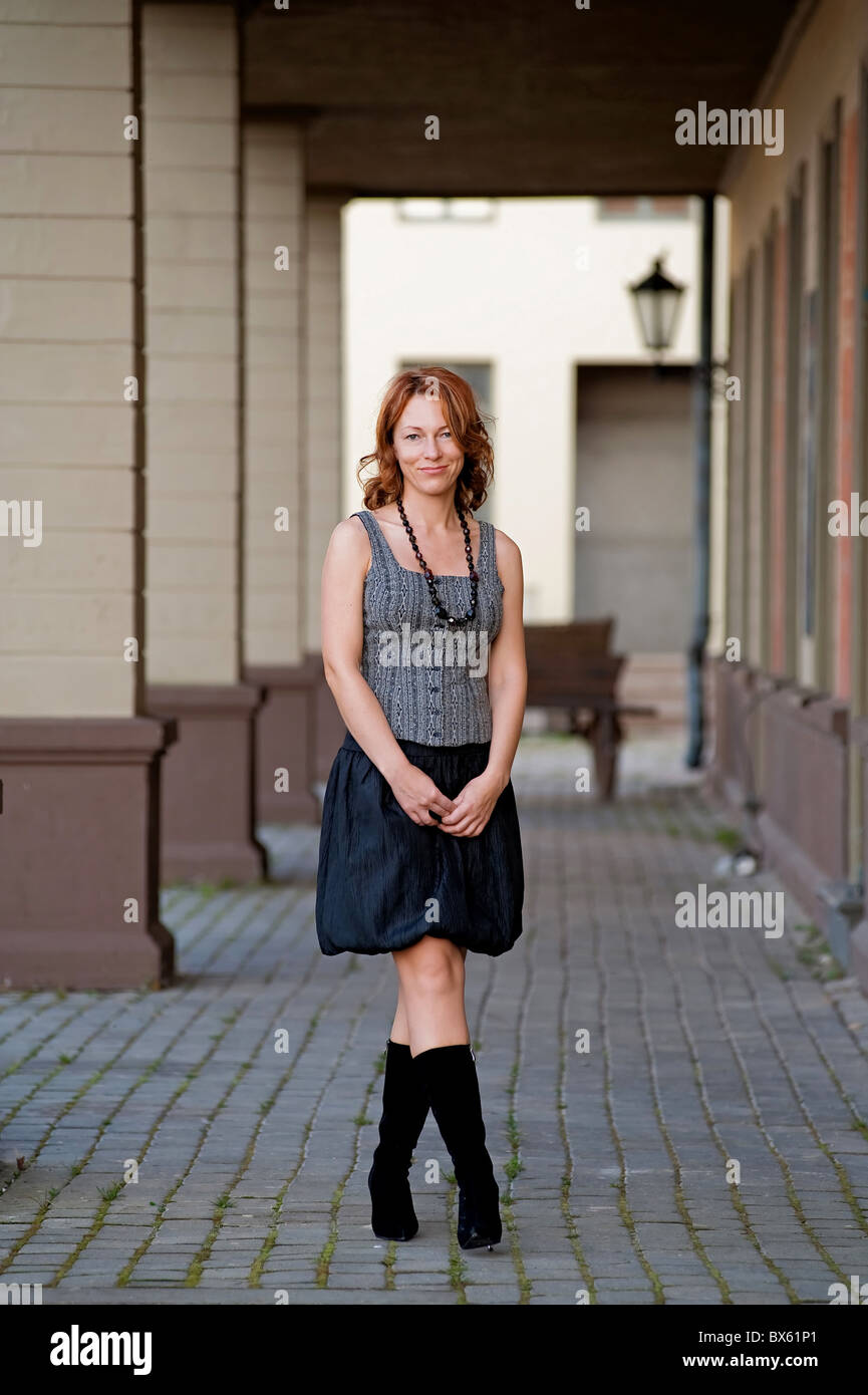 Belle femme mature, posant sur le trottoir rue près de l'arc Photo