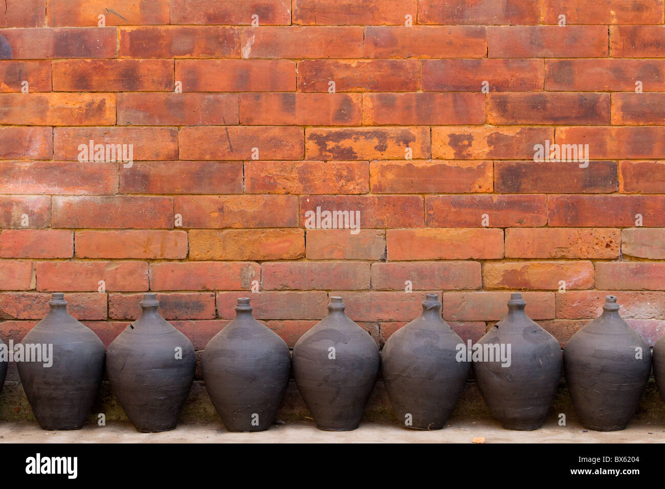 Poterie et mur de brique orange dans la ville de Bhaktapur, Népal Banque D'Images