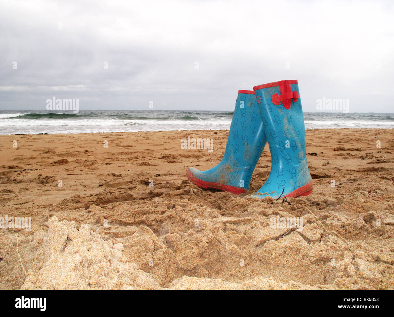 Abandonné paire de bottes en caoutchouc sur la plage Banque D'Images