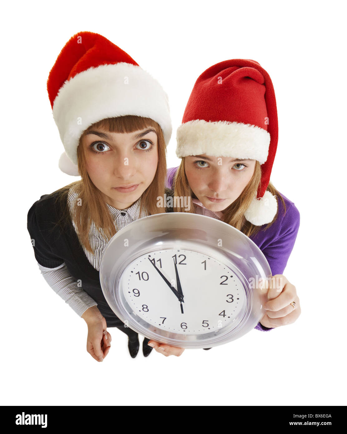 Deux jeunes filles sont prêts à accueillir la nouvelle année avec une montre dans sa main isolé sur fond blanc Banque D'Images