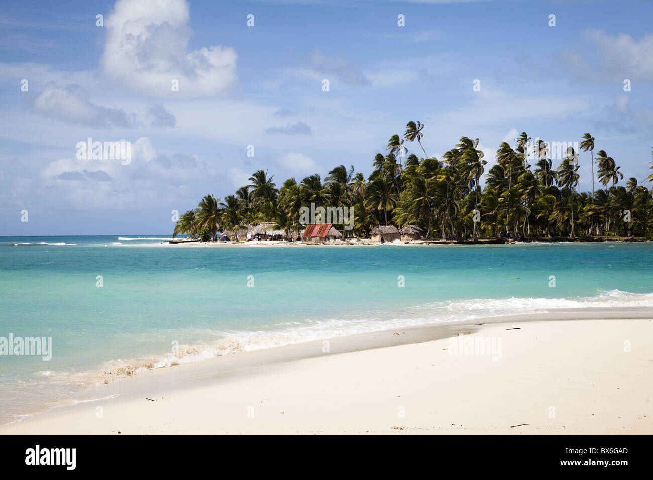 Palmiers et de chaume huts sur Diablo Island vu de la plage sur l'île de chien, îles San Blas, Panama, Amérique Centrale Banque D'Images