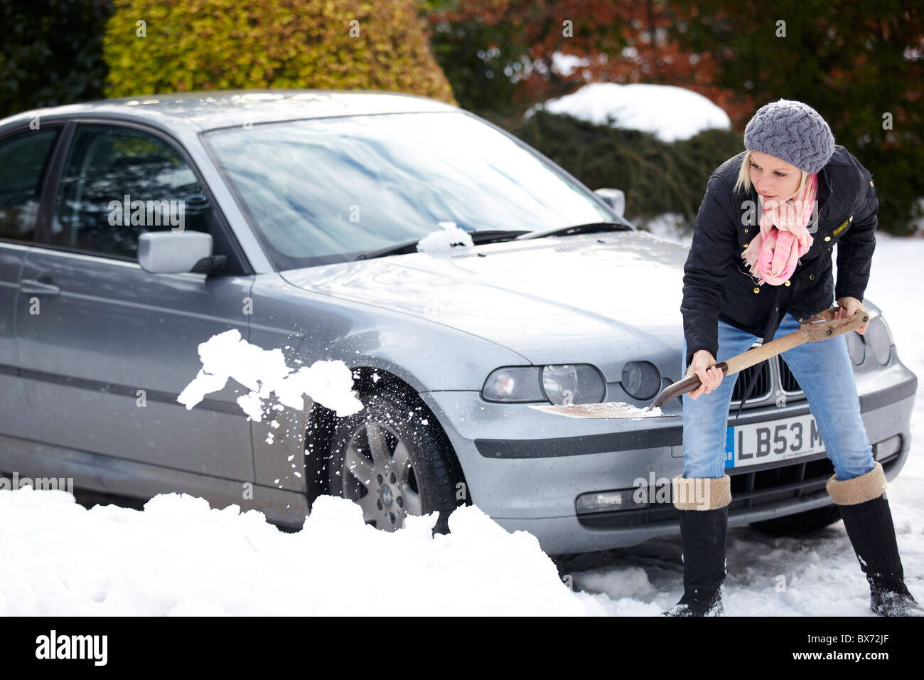 Femme de creuser dehors la neige de voiture Banque D'Images